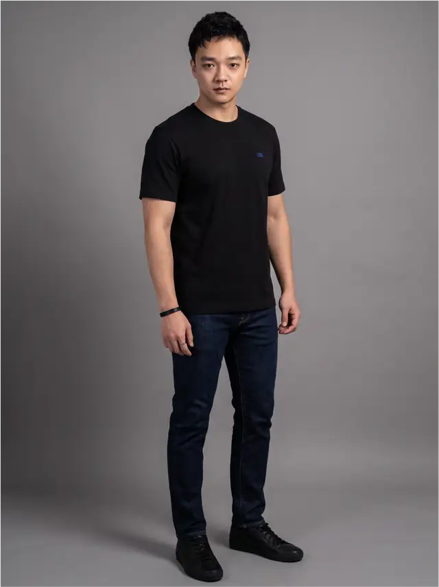 Justin Won in a black tee and dark denim, off-duty
